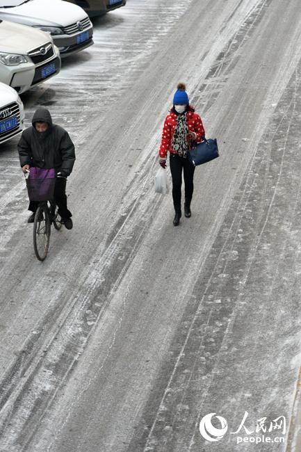 1月29日凌晨北京城區飄起零星雪花，房頂、街道披上一層白紗。（人民網記者 翁奇羽 攝）