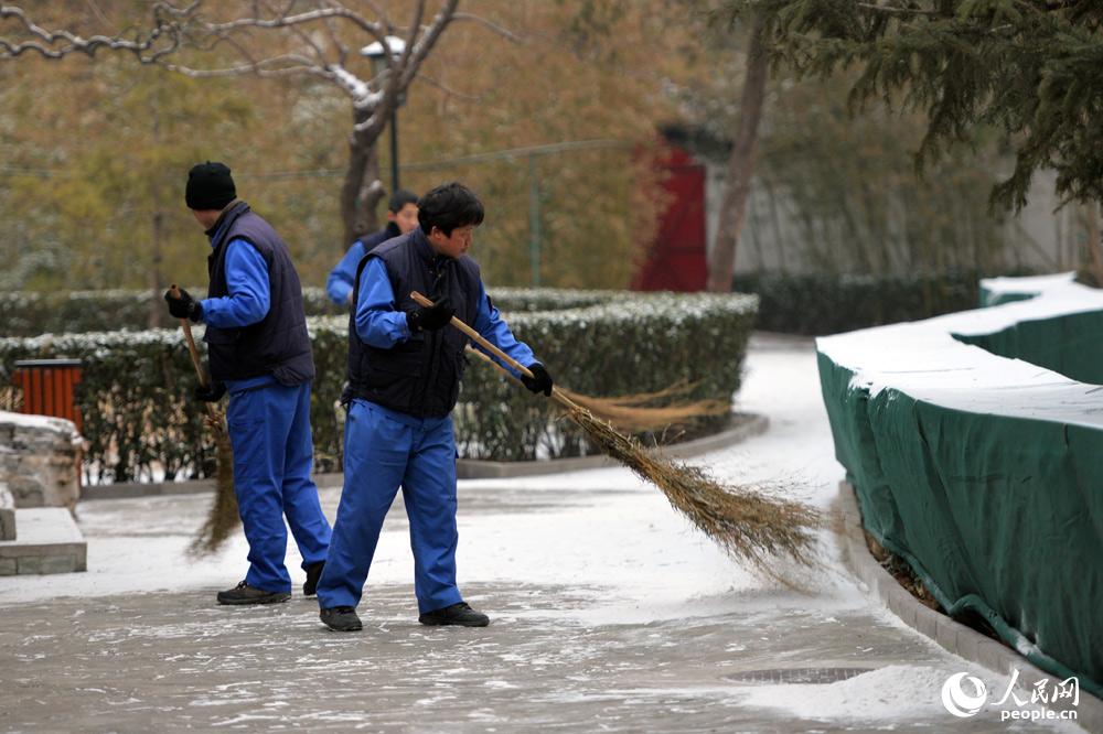 1月29日凌晨北京城區飄起零星雪花，房頂、街道披上一層白紗。（人民網記者 翁奇羽 攝）