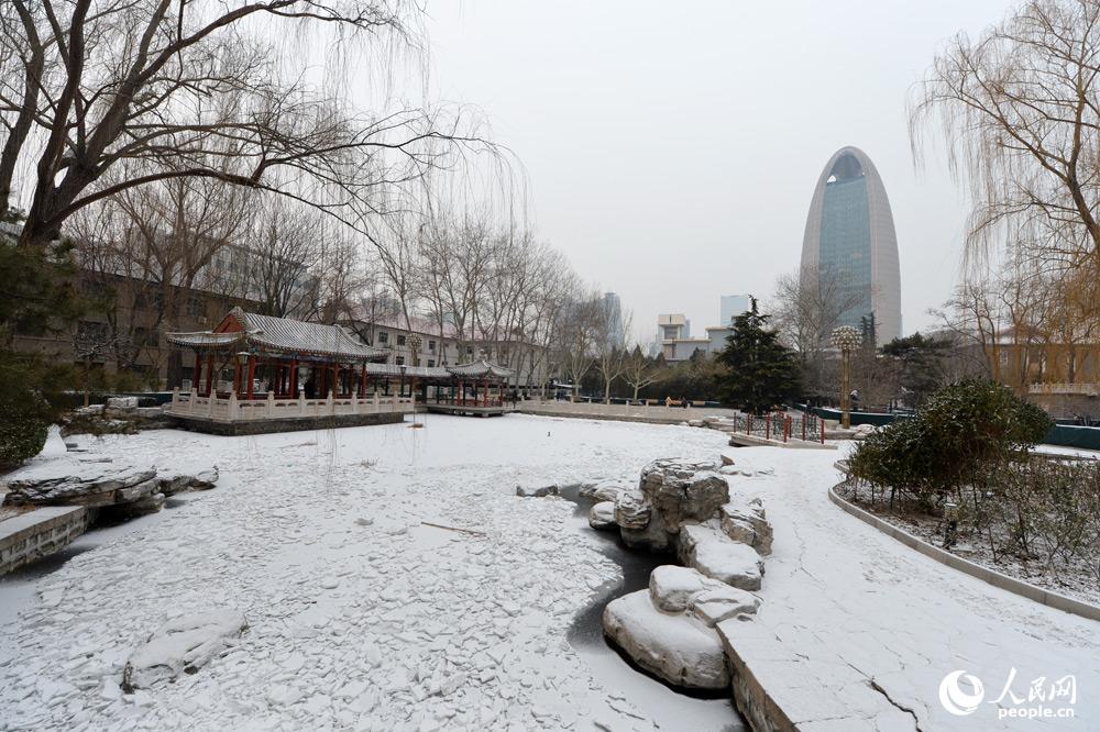 1月29日凌晨北京城區飄起零星雪花，房頂、街道披上一層白紗。（人民網記者 翁奇羽 攝）