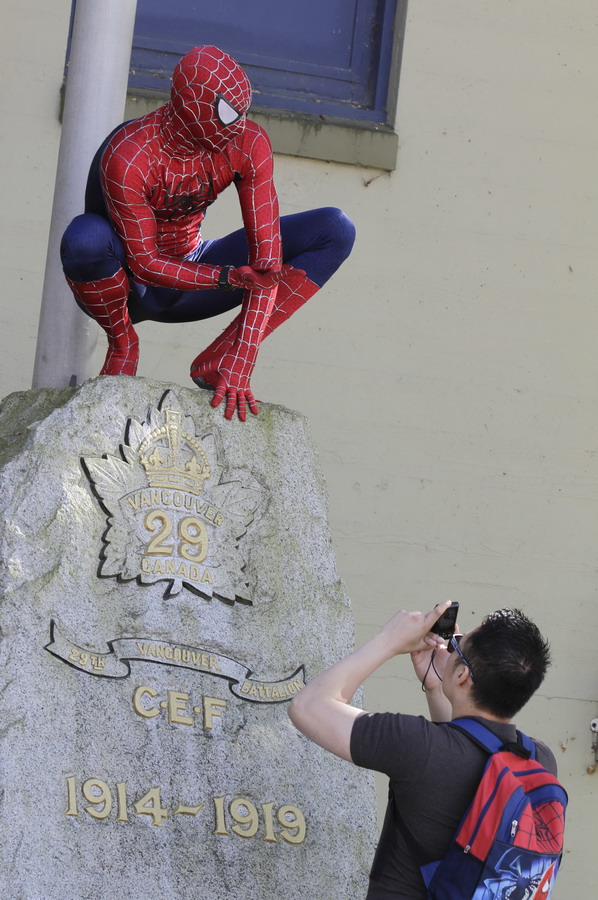 6月10日，在加拿大溫哥華，一名男子在拍攝蜘蛛俠造型的參賽者。新華社發（梁森 攝）