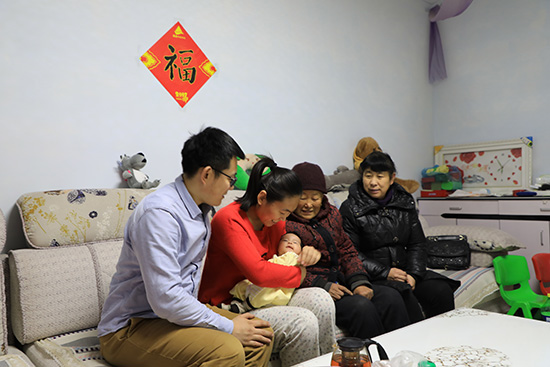 山東省濱州高新區小營街道辦事處小后村的王衡一家在新居內照看剛出生不久的女兒。
