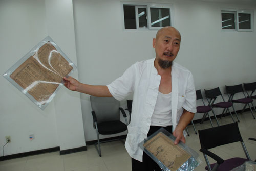冯艺向记者展示自己的藏品(图片来源:人民网传媒频道 燕帅/摄)